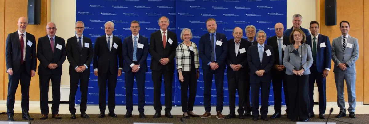 Members of the entire panel standing together and smiling for a photo 