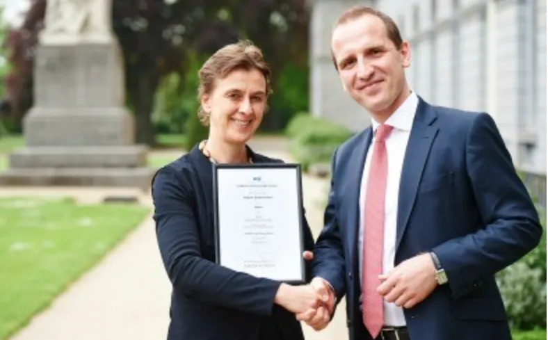 Woman and man shaking hands. Woman receiving an award. 